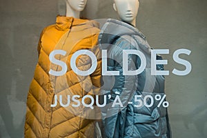 Discount sign `SOLDES` jusqu`a 50%` in french,  the traduction of  sales until 50% in english on the window of fashion store