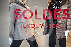 discount sign SOLDES jusqu'a 50% in french, ) on the window of fashion store