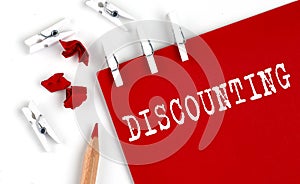 DISCOUNTING text on the red paper with office tools on white background photo