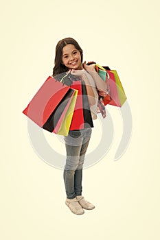 Discounts and promo codes. Girl carries shopping bags isolated on white background. Girl fond of shopping. Child cute