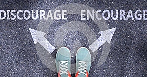 Discourage and encourage as different choices in life - pictured as words Discourage, encourage on a road to symbolize making