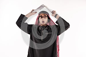 Discouraged Arab man in keffiyeh holds laptop