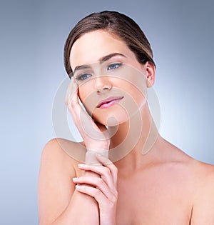 Discover the beauty in you. a beautiful young woman touching the soft skin on her face.