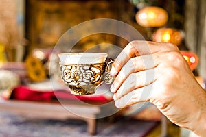 Discover the Delights of Traditional Turkish Drinks: Hand Holding a Cup of Çay to ?algam