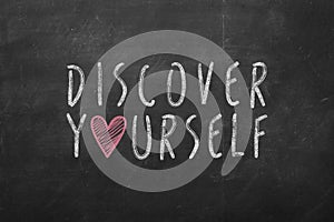 Discover yourself text hand-written on black chalkboard