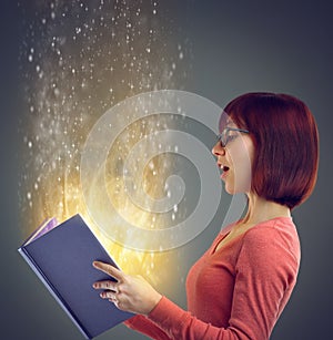 Discovering a world of magic. A cropped shot of a young adult reading a book with glowing pages.