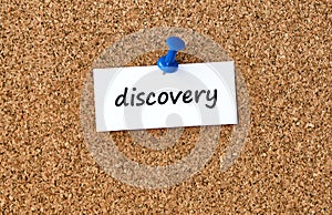 Discovery. Word written on a piece of paper, cork board background