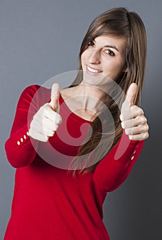 Discreet beautiful young woman smiling with thumbs up photo