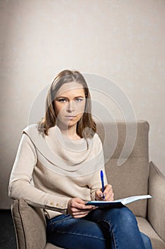 Discreet psychologist sitting with notebook for notes