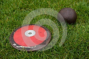 Discus and shot put ball on the grass