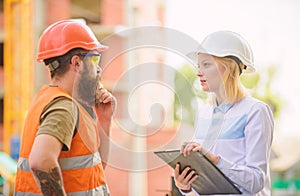 Discuss progress project. Construction project inspecting. Safety inspector concept. Woman inspector and bearded brutal photo