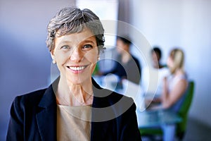 Discussing business strategy. Portrait of a businesswoman standing in front of her colleagues during a meeting.