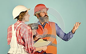 Discussing renovation with contractor. Price list. Couple look documents. Woman and man safety hard hat. Couple planning