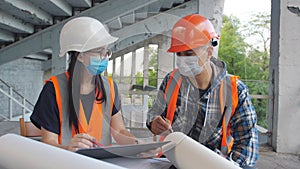 Discussion of construction work between a female engineer and a male foreman in medical masks on the construction site.