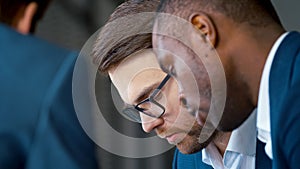 Discussion of work issues at a meeting in the office: young businessmen working as a team