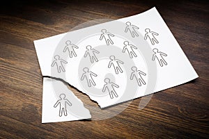 Disengaged Employees concept. Figures of people on a sheet of paper and one is torn off.