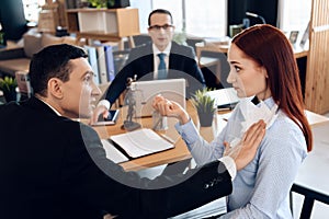 Disgruntled adult man pokes torn marriage contract into red-haired woman in divorce lawyer`s office.