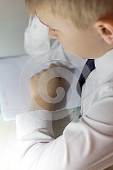 A disgruntled boy student thinks of a traditional notebook in a cage