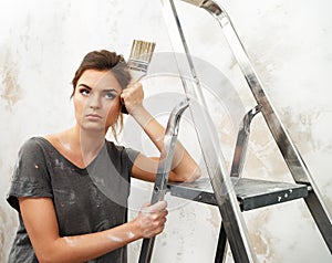 Disgruntled woman with ladder and brush