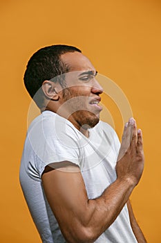 Disgust Afro-American man is looking disgustingly against orange background