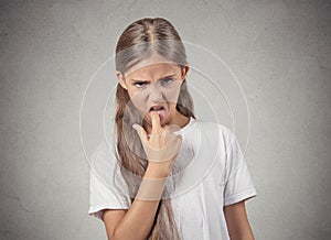 Disgusted, annoyed off teenager girl with finger in mouth gesture