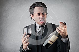 Disgusted businessman with a glass of wine
