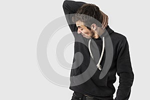 Disgusted caucasian young man is sniffing his own armpit. Isloated on white background