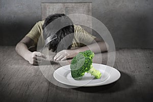 Disgusted child refusing to eat healthy green broccoli feeling upset in kid nutrition education on healthy fresh food and young