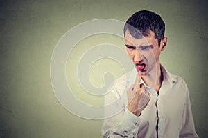 Disgusted man with finger in mouth displeased ready to throw up