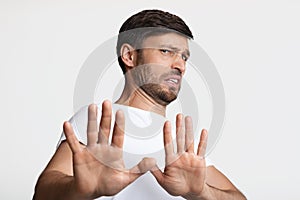 Disgusted Man Gesturing Stop Avoiding Something Over White Background