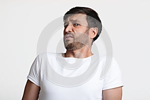 Disgusted Man Smelling Unpleasant Odor Expressing Negative Emotions, White Background