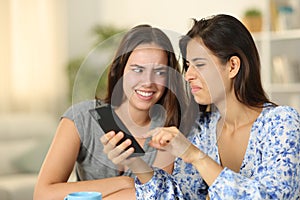 Disgusted women watching nasty content on phone photo