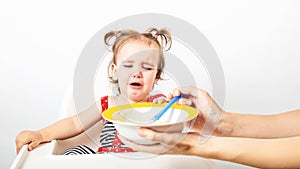 Disgusting kids nutrition. Cute baby crying, doesn`t want to eat meal