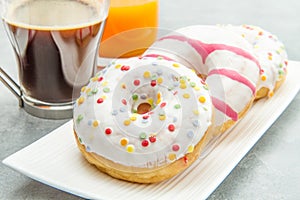 Dish with assorted donuts, coffee and juice