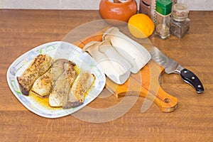 Dish with baked Eringi mushrooms and uncooked mushrooms beside