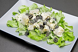 Dish of cod salad with black olives