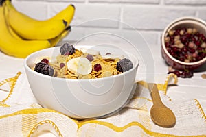 Dish with Corn Flakes, Banana, Berries and Wooden Spoon on white background, Healthy Breakfast