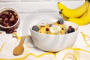 Dish with Corn Flakes, Banana, Berries and Wooden Spoon on white background, Healthy Breakfast