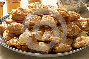 Dish with deep fried, square shaped, Rghayef honey cookies