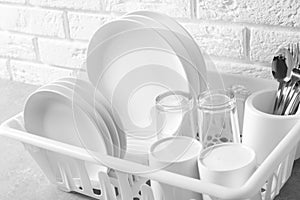 Dish drainer with clean plates on table