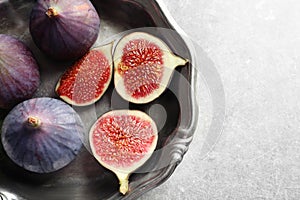 Dish with fresh ripe figs on gray background, top view