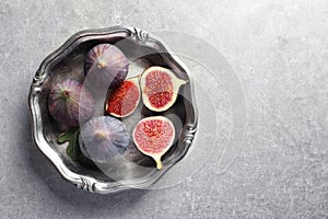 Dish with fresh ripe figs on gray background, top view