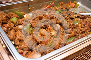 A dish of fried curry flavoured meat on a large open tray