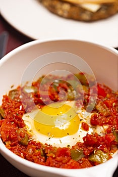 A dish of the fried egg with the stewed peppers