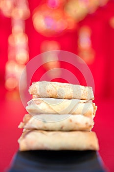 A dish of fried spring rolls on the background of festive red