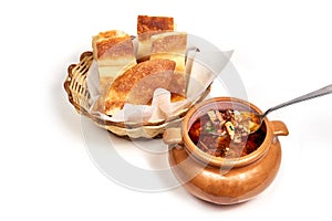 Dish of hodgepodge soup served with a slice of bread photo