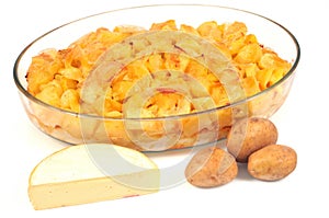 Dish of homemade tartiflette and its ingredients close-up on a white background