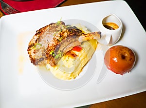 A dish of lamb steak with apple and smash potato.