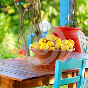 A dish of lemons in typical greek outdoor cafe