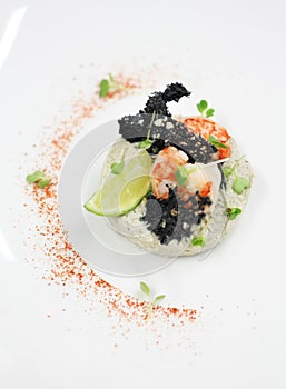 Dish with lime garnish, prawns and some vegetables on the top photo